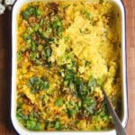 Baked loaded rice with a large silver spoon.