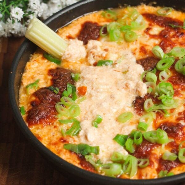 Buffalo chicken dip baked and topped with scallions.
