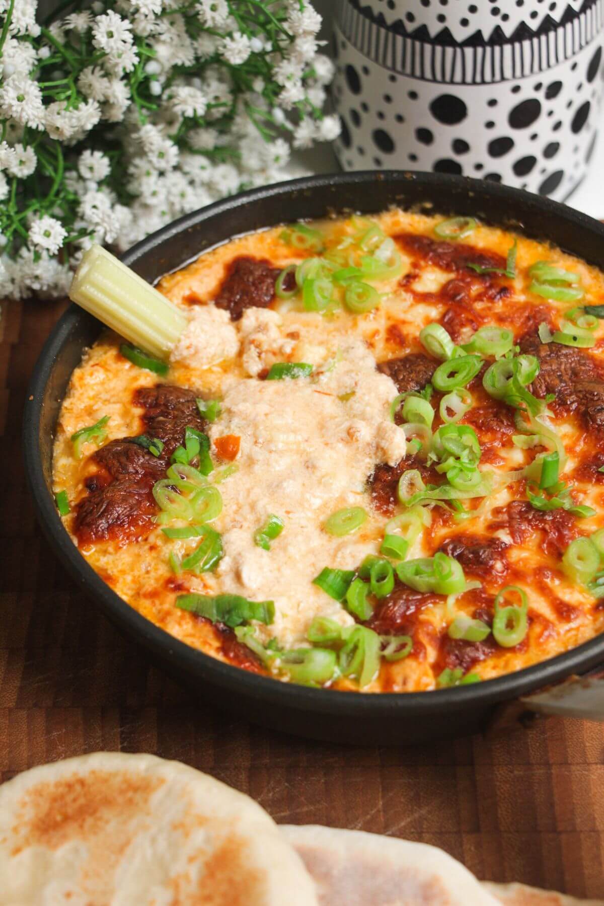 Buffalo chicken dip baked and topped with scallions.
