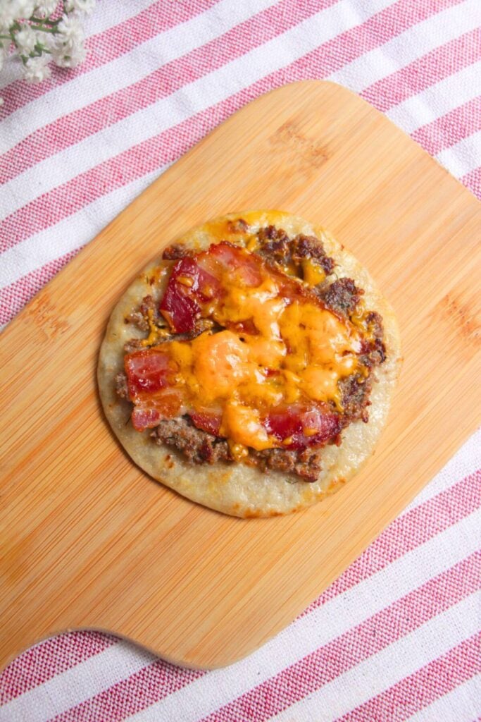 Cheese melted on top of cheeseburger taco.