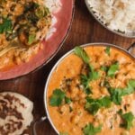 Coconut chickpea curry, rice and naan on a wooden surface.