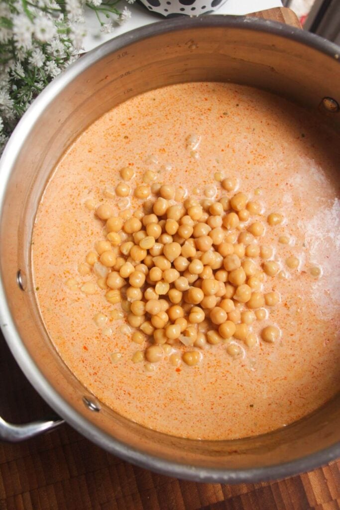 Chickpeas added to coconut curry sauce.