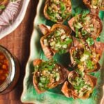 Mini dumpling cups on a green plate.