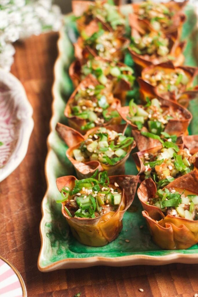 Mini dumpling cups on a green plate.