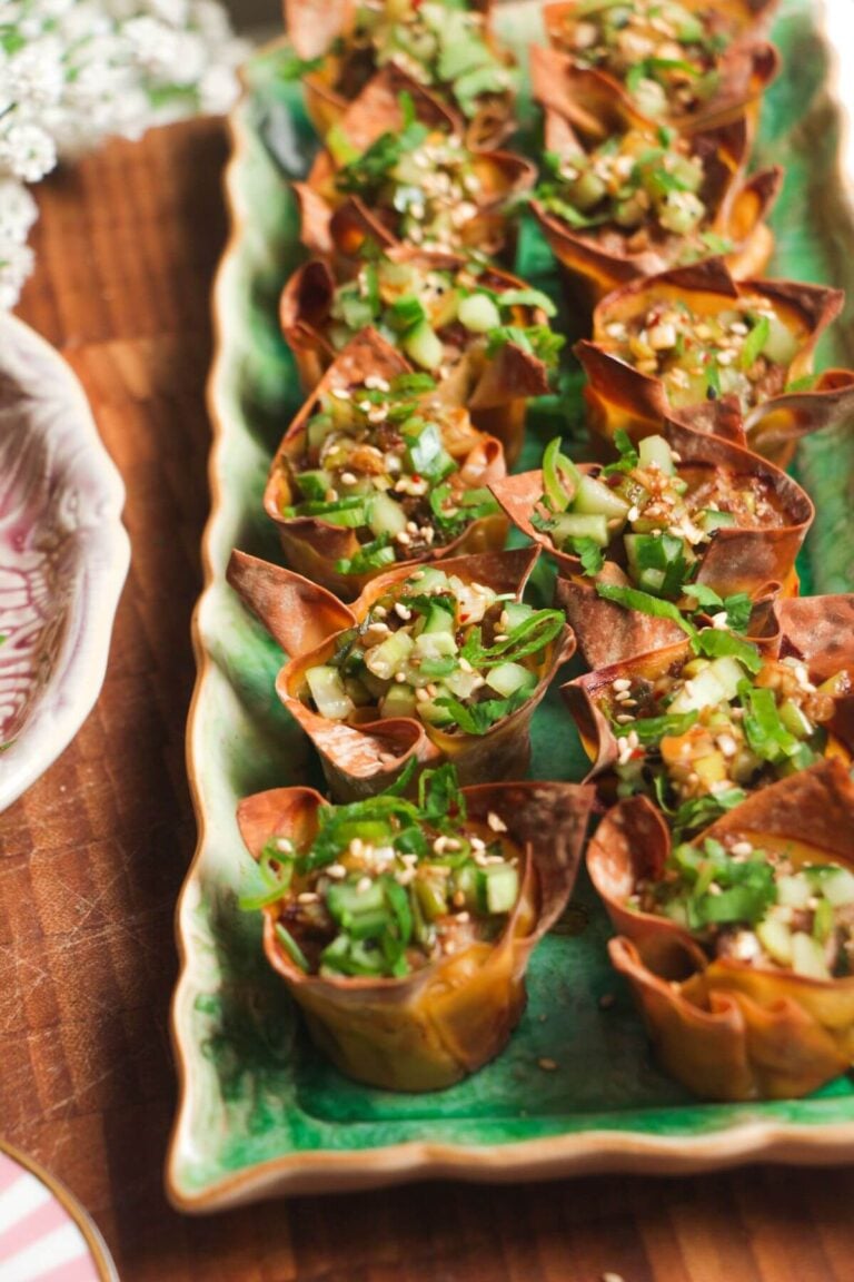 Mini dumpling cups on a green plate.