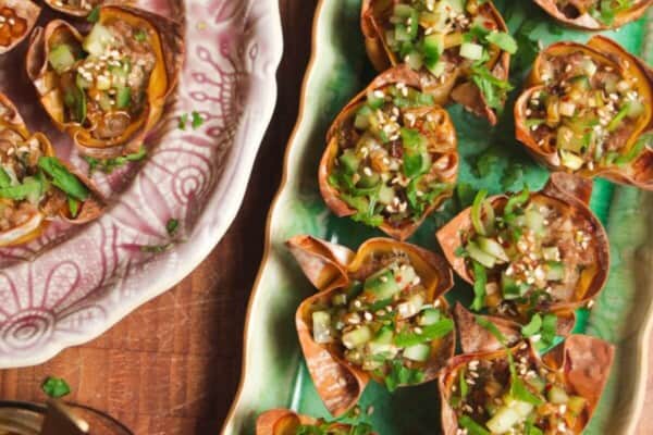 Mini dumpling cups on a green plate.