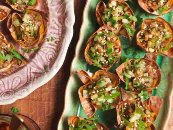 Mini dumpling cups on a green plate.