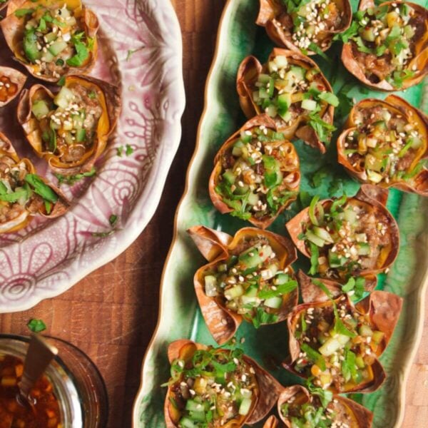 Mini dumpling cups on a green plate.