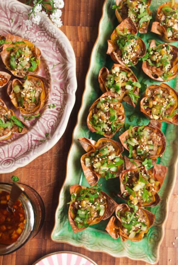Mini dumpling cups on a green plate.