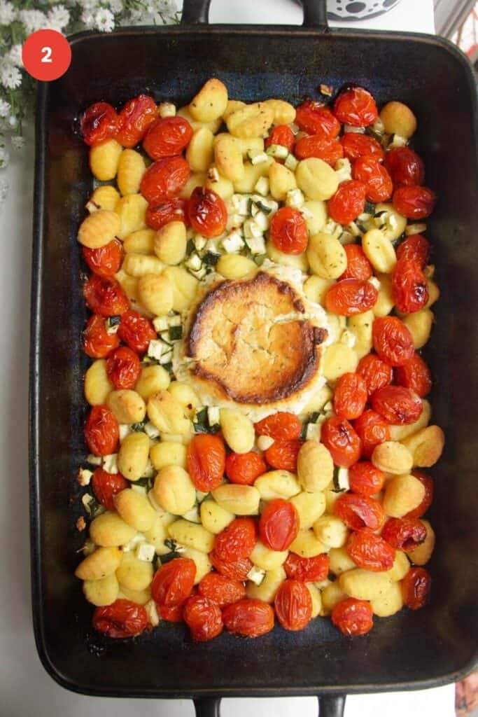 Baked tomatoes, zucchini, Boursin and gnocchi in baking dish.