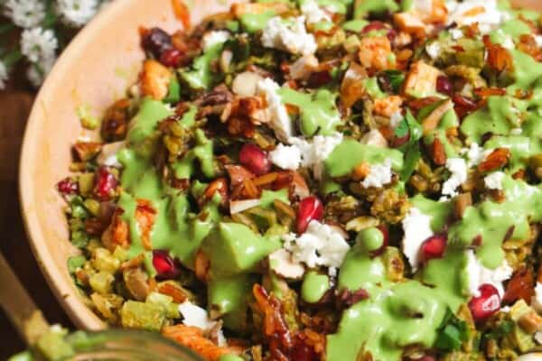 Mediterranean crispy rice salad in a pink bowl.