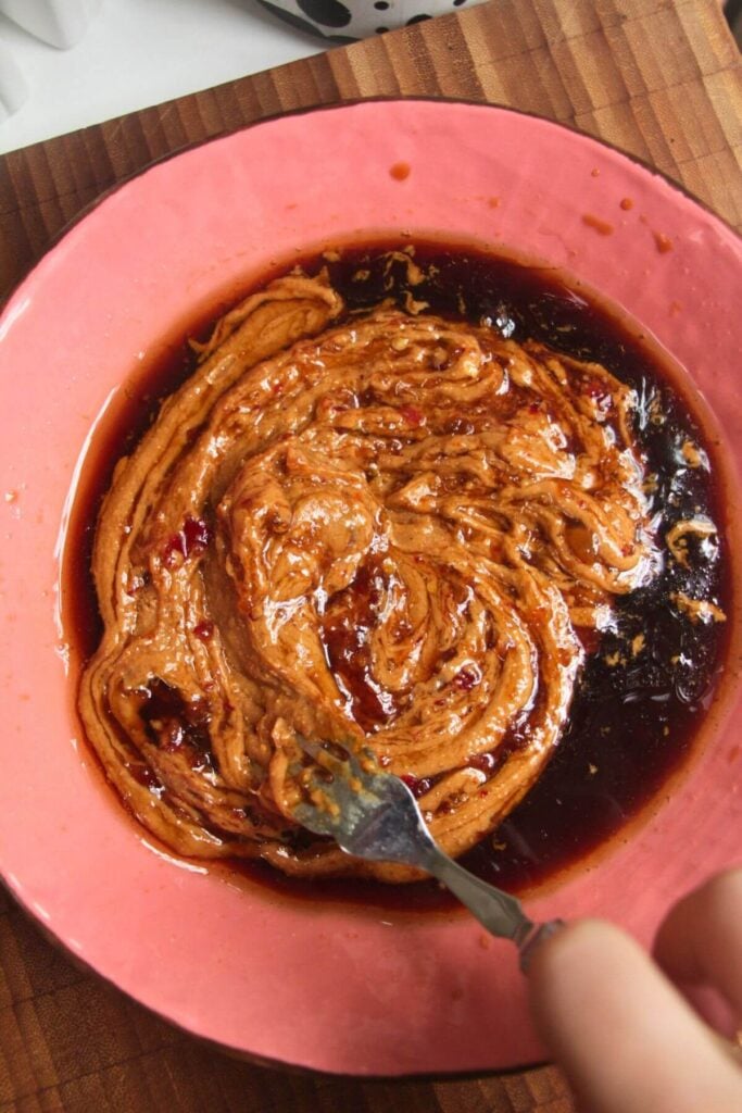 Mixing peanut butter with dressing ingredients.