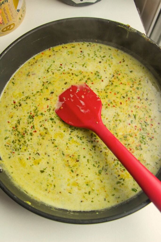Creamy pesto sauce in a large pan.