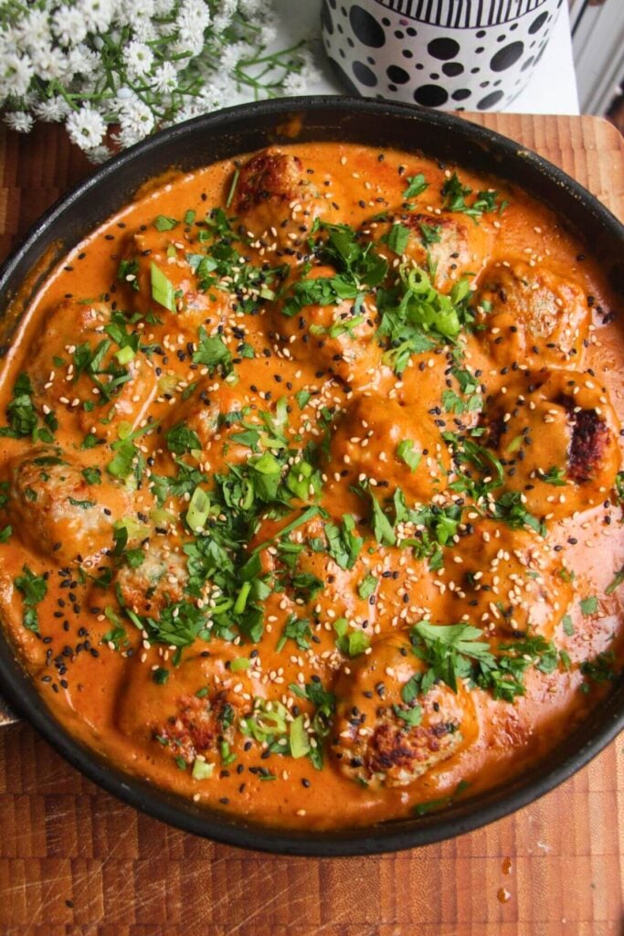 Chicken meatballs in a satay sauce, topped with cilantro and scallions.