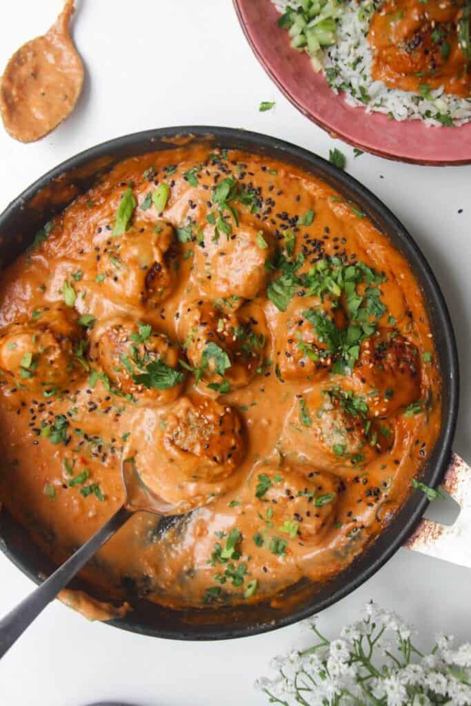 Chicken meatballs in a satay sauce, topped with cilantro and scallions.
