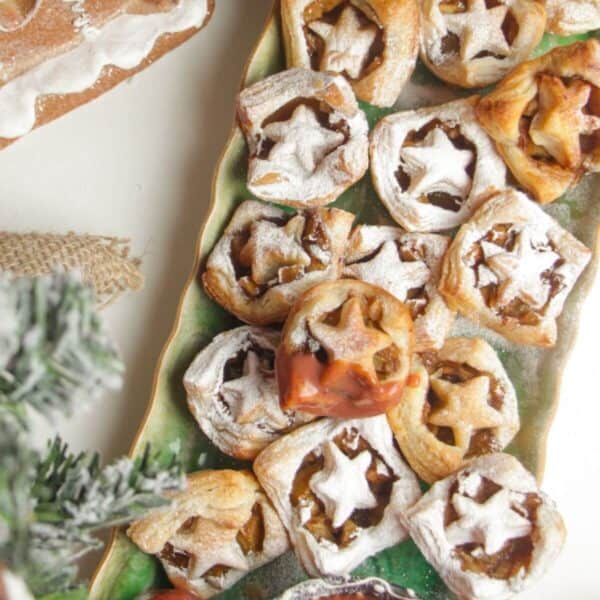 A platter of mini apple pie bites dusted with icing sugar.