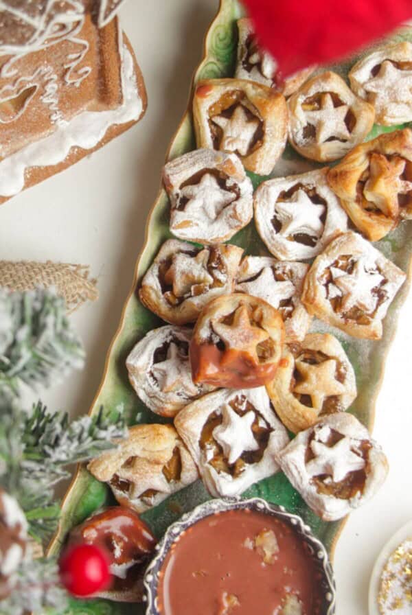 A platter of mini apple pie bites dusted with icing sugar.
