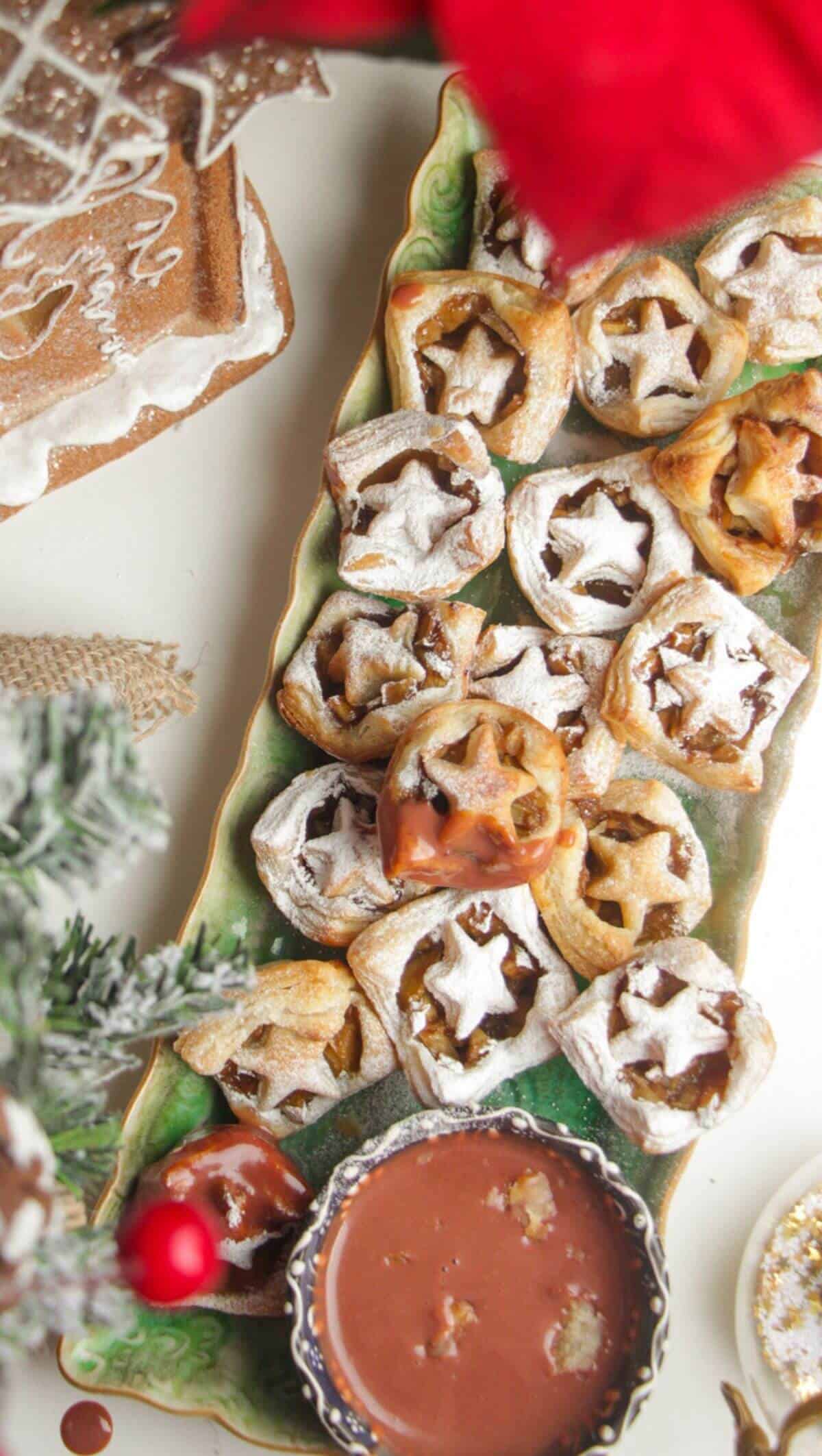 A platter of mini apple pie bites dusted with icing sugar.