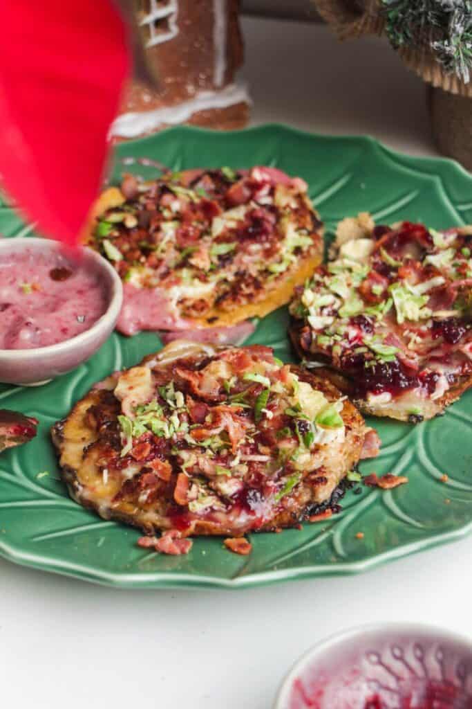 Three smash festive tacos on a green plate.