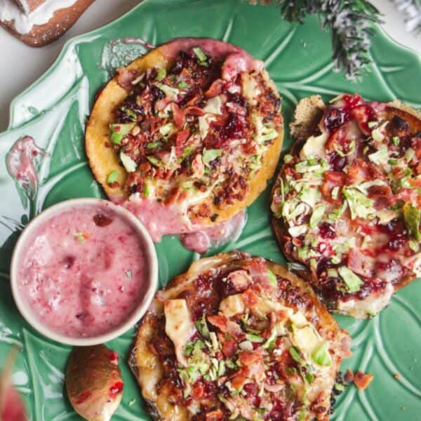 Three smash festive tacos on a green plate.