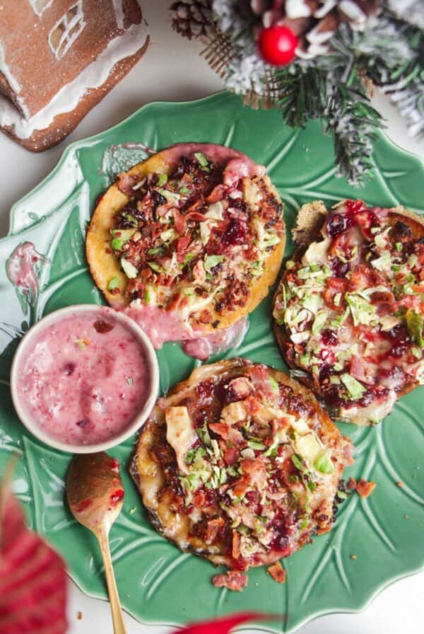 Three smash festive tacos on a green plate.