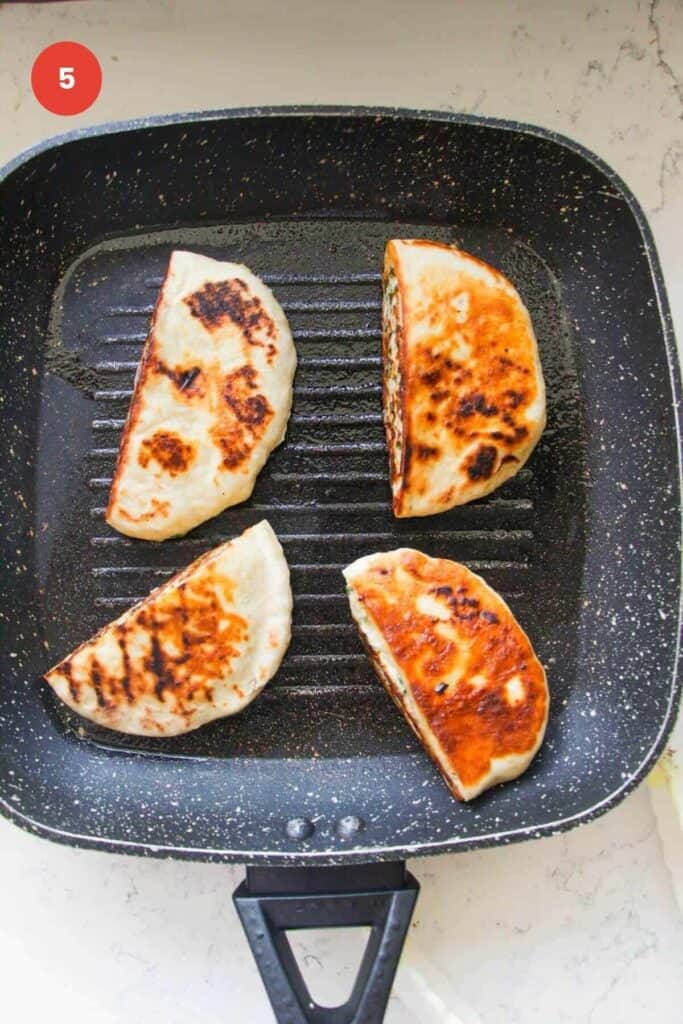 Cooked dumpling flatbreads in a pan.