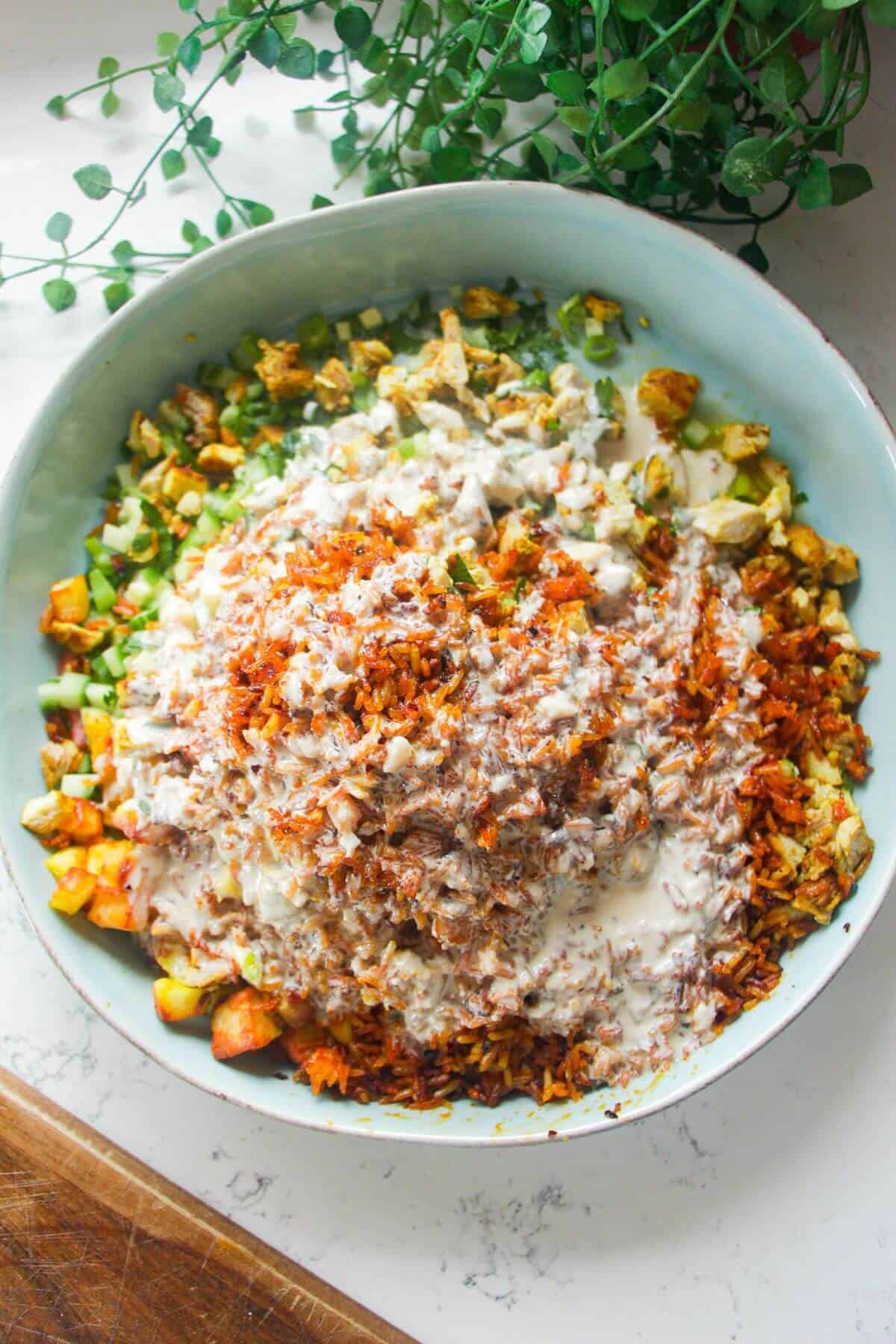 Tahini dressing poured over shawarma crispy rice salad.