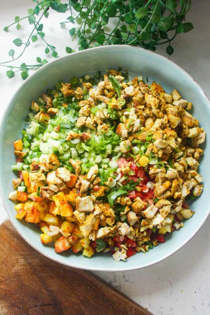 Ingredients for chicken shawarma crispy rice salad in a large bowl.