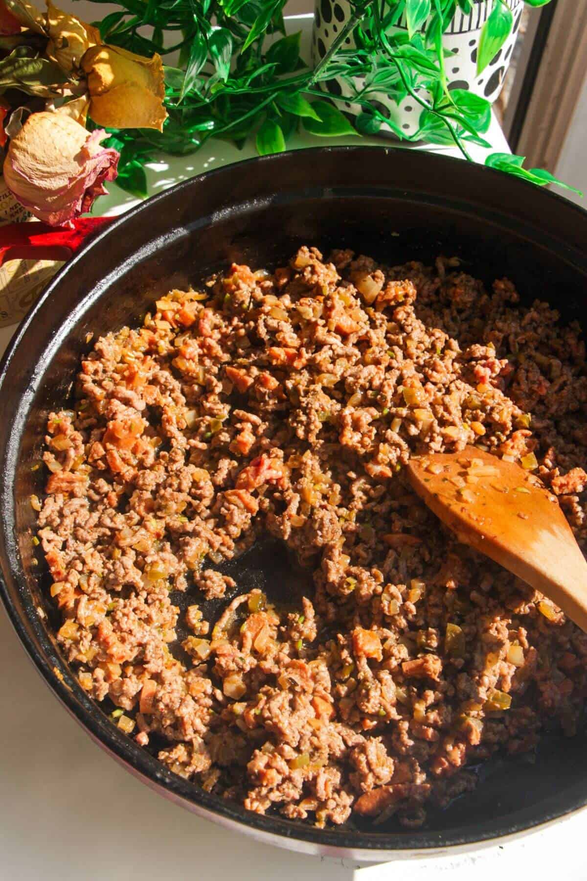 Ground beef added to chorizo and spices in a large pan.
