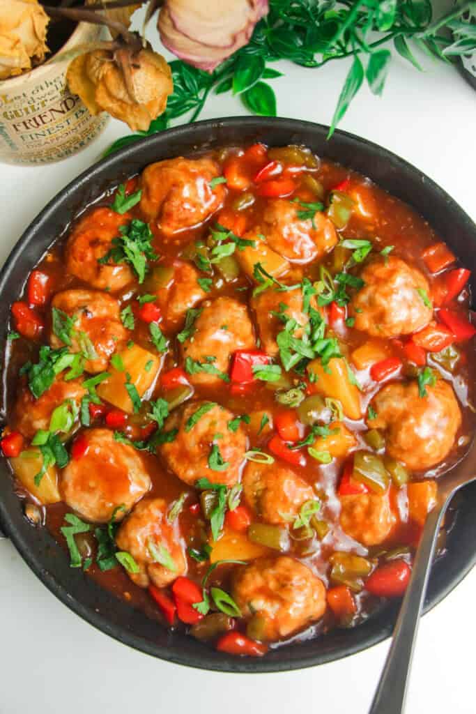 Sweet and sour chicken meatballs in a pan.