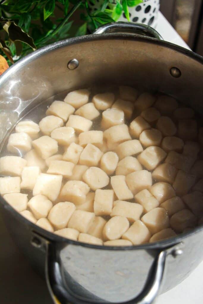 Cottage cheese gnocchi boiling in a large pot.