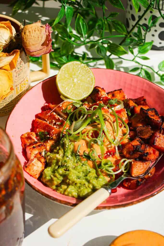 Chicken, sweet potato, whipped cottage cheese and avocado in a pink bowl.
