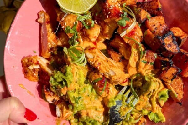 Chicken, sweet potato, whipped cottage cheese and avocado in a pink bowl.