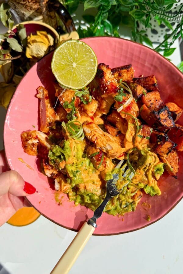 Chicken, sweet potato, whipped cottage cheese and avocado in a pink bowl.