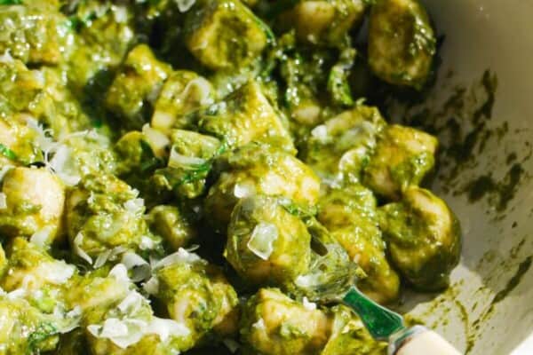 Cottage cheese gnocchi tossed with a green goddess sauce in a white bowl.