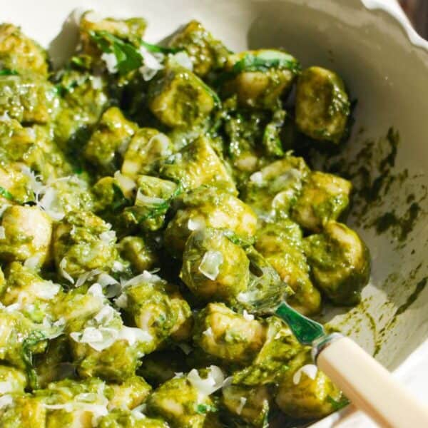 Cottage cheese gnocchi tossed with a green goddess sauce in a white bowl.