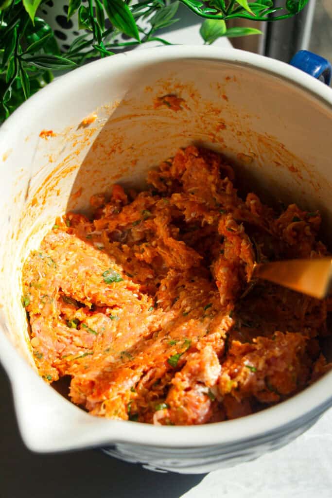 Ingredients for coconut gochujang meatballs combined in mixing bowl.