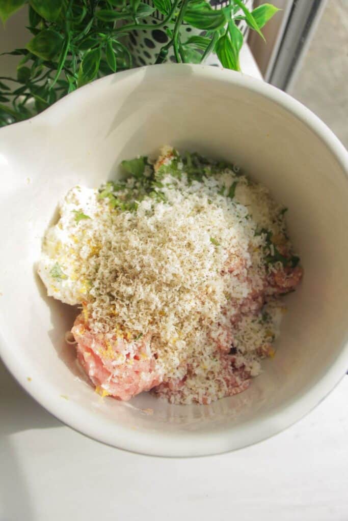 Ground chicken, panko breadcrumbs, parmesan in a mixing bowl.