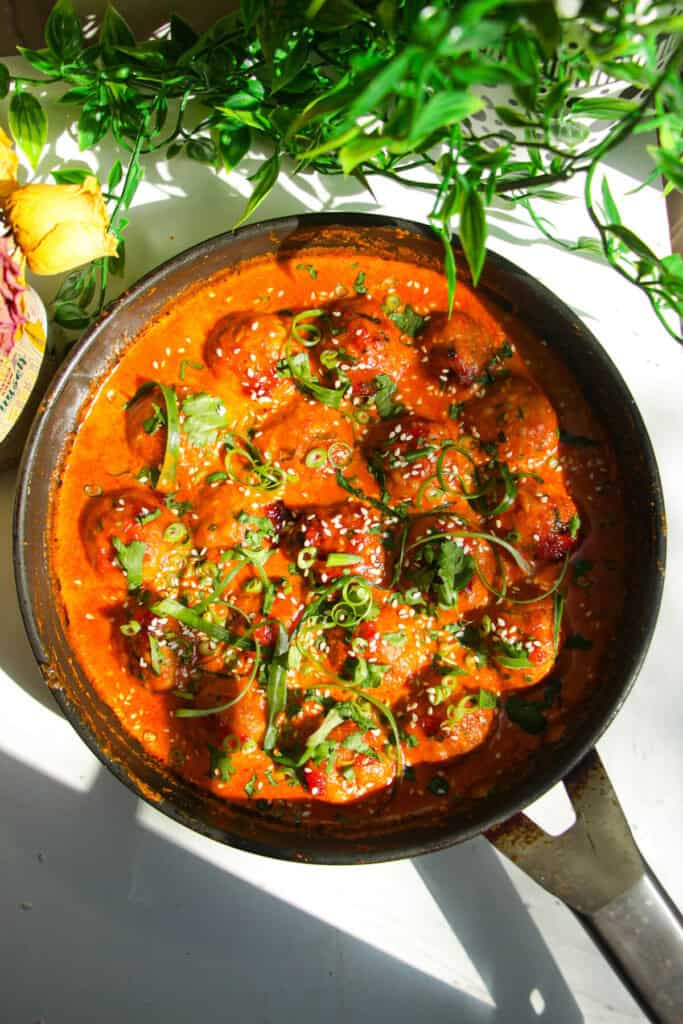 Scallions and cilantro on coconut gochujang meatballs.