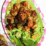 Chicken Caesar meatballs on a pink and white plate.