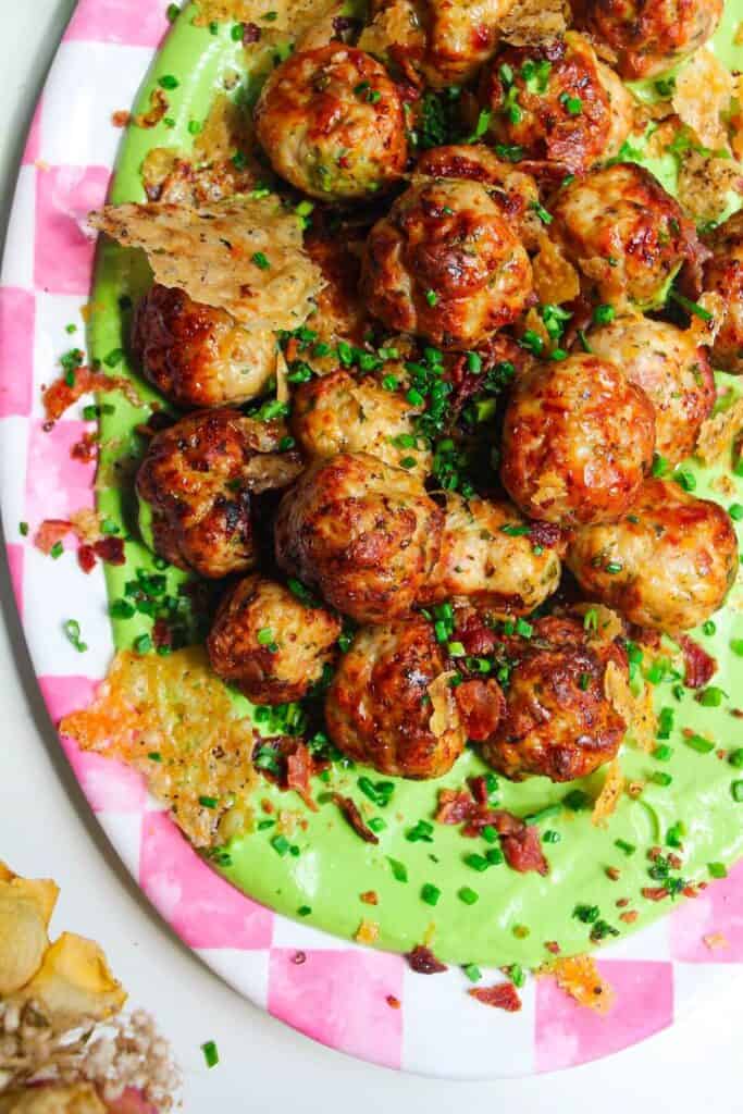 Chicken Caesar meatballs on a pink and white plate.