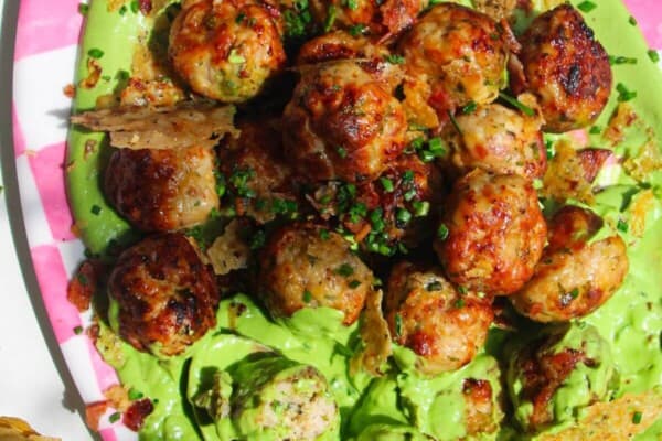 Chicken Caesar meatballs on a pink and white plate.