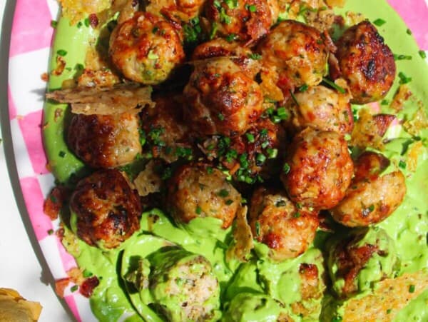 Chicken Caesar meatballs on a pink and white plate.