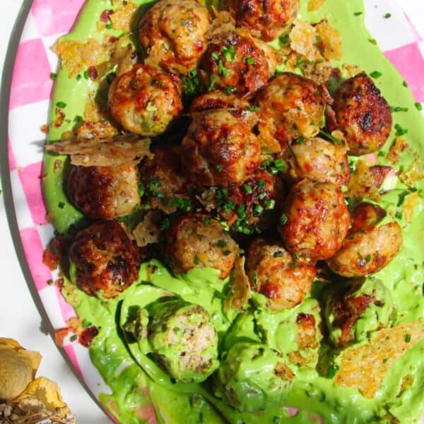 Chicken Caesar meatballs on a pink and white plate.