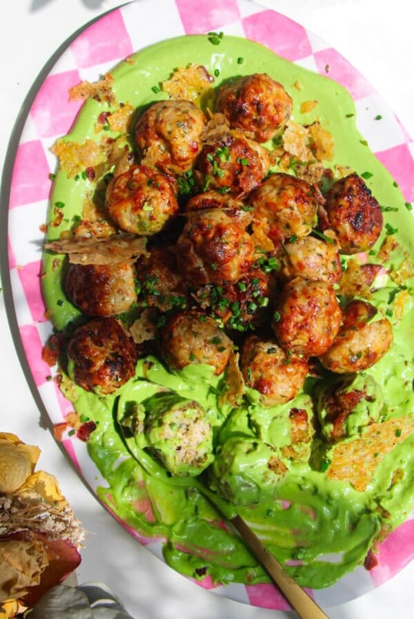 Chicken Caesar meatballs on a pink and white plate.