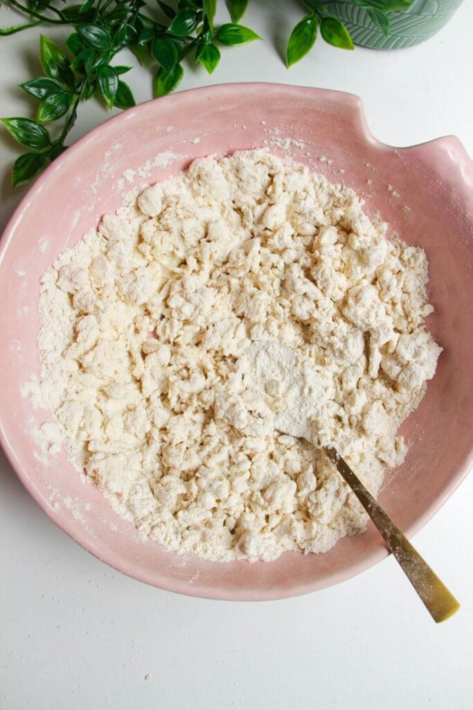 Flour and cottage cheese mixed in a pink bowl.