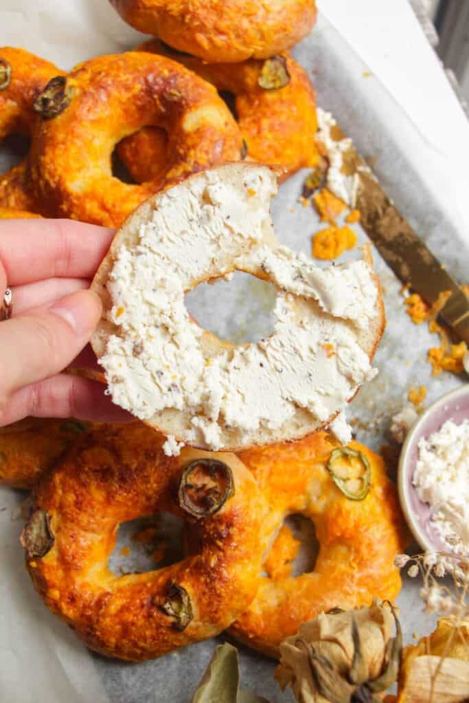 Holding a cottage cheese bagel spread with Boursin cheese.