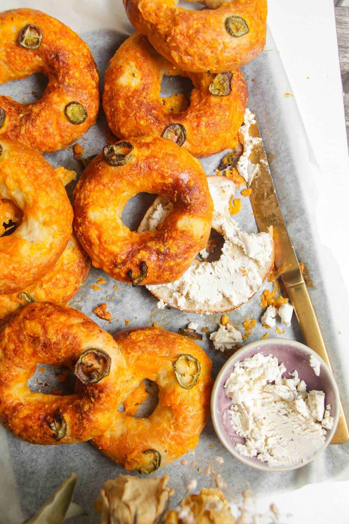 Cottage cheese bagels on a baking tray with Boursin cheese on the side.
