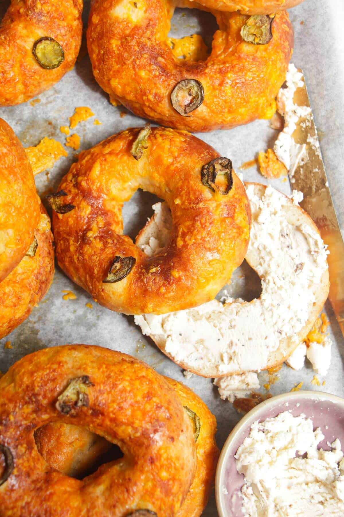 Cottage cheese bagels on a baking tray with Boursin cheese on the side.