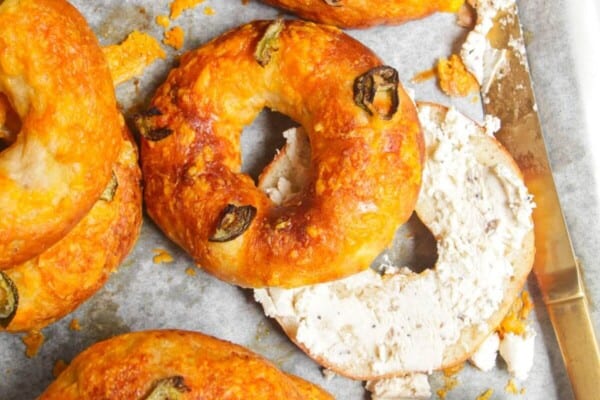 Cottage cheese bagels on a baking tray with Boursin cheese on the side.